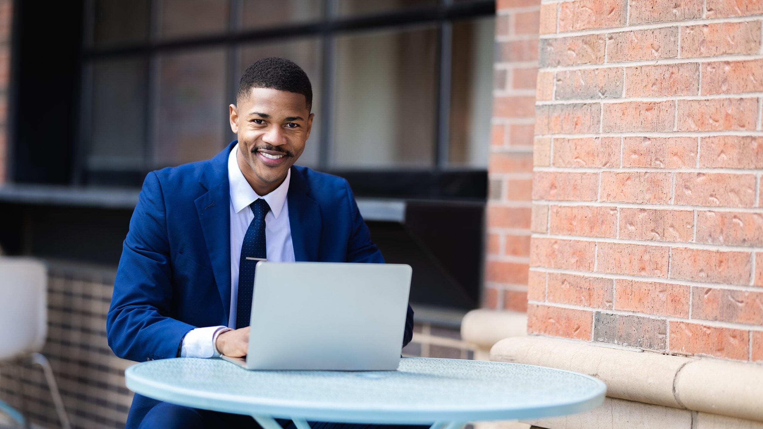 Man sitting outside working on a computer.