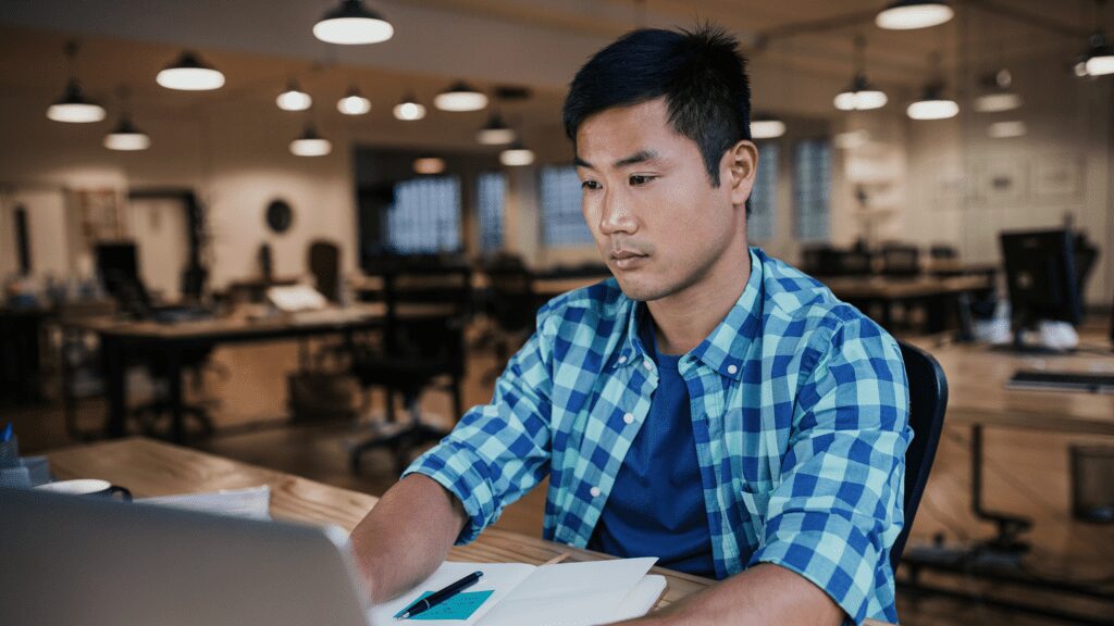 Man working on a laptop in the library.